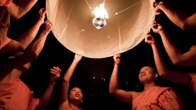 Monjes budistas lanzan una linterna durante el festival Yee Peng en Chiang Mai.