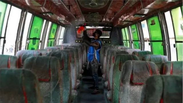 করোনাভাইরাসের সংক্রমণ ঠেকাতে একটি বাস জীবানুমুক্ত করার জন্য স্প্রে করছেন এক স্বেচ্ছাসেবী।