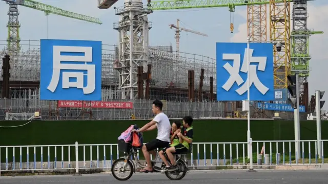 Homem passabônus pin upbicicletabônus pin upfrente ao estádiobônus pin upconstrução do Guangzhou FC