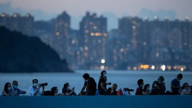 Moon gazers and amateur astronomy photographers wait for the "super blood moon" rise over the South China Sea during a moon eclipse in Hong Kong, China, 26 May 2021.