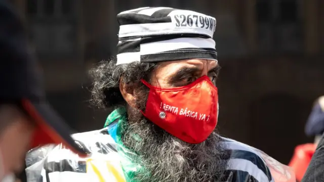 Hombre con mascarilla con mensaje sobre la renta básica.