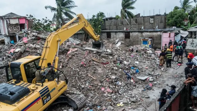 Guindaste é usado para retirar escombros1xbet aviatorum bairro1xbet aviatorLes Cayes, no Haiti