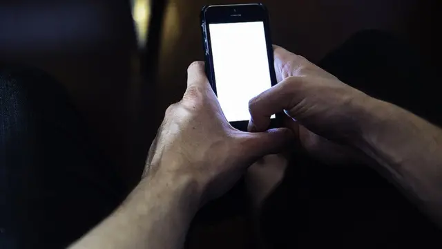 رجل يمسك هاتفه