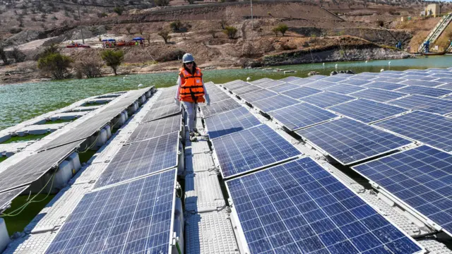 Mujere caminando entre paneles solares