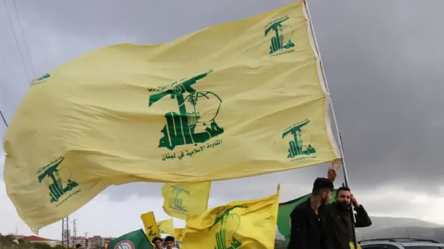 متظاهرون يحملون علم حزب الله في لبنان