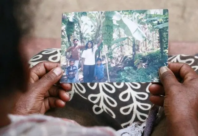 తన పిల్లల ఫోటో చూస్తున్న తల్లి