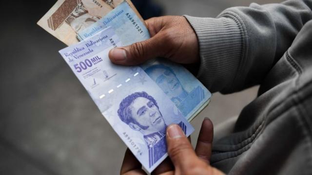 Una persona sostiene unos billetes de 500.000 bolívares.