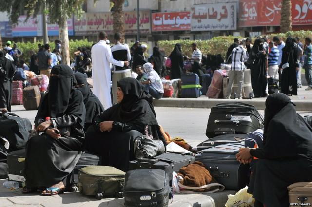 عاملات وافدات ينتظرن الحصول على أغراضهن قبل ركوب باصات الشرطة في السعودية - صورة أرشيفية.