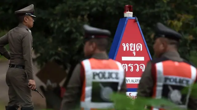 Police guard a road to the cave area - 9 July