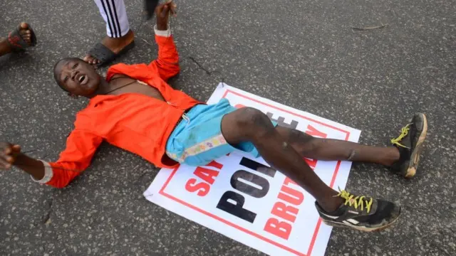 De jeunes manifestants ENDSARS affichent leurs pancartes contre le harcèlement, les meurtres et la brutalité de l'unité de la police nigériane appelée Special Anti-Robbery Squad (SARS) à l'arrêt de bus Alawusa, le long de Lagos Ibadan-Expressway à Ikeja , le 13 octobre 2020