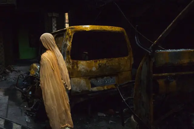 Kendaraan terbakar di Khajuri Khas yang dilanda kerusuhan.