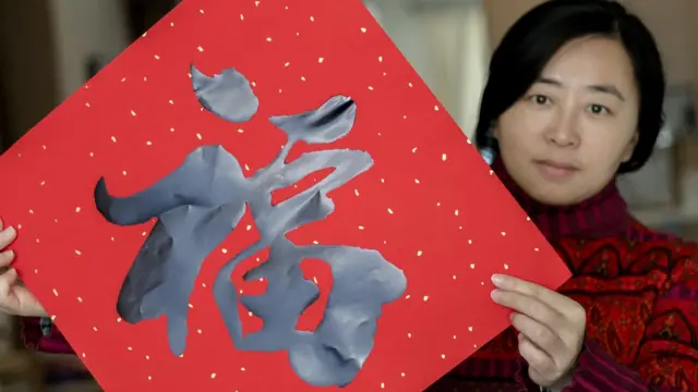 Una mujer con un sobre rojo