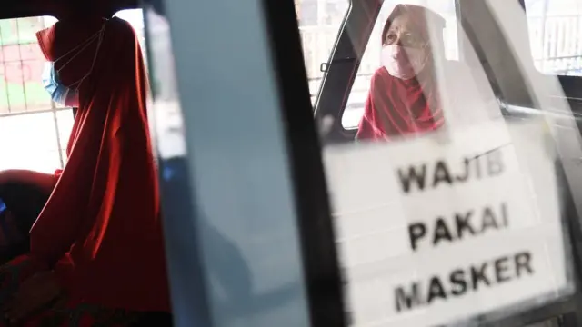 Penumpang mengenakan masker dan menjaga jarak di dalam angkutan MikroTrans JakLingko di Tanah Abang, Jakarta, Kamis (22/7/2021).