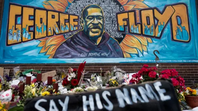 أكاليل من الورود موضوعة أسفل جدارية للأمريكي أسود البشرة جورج فلويد الذي قتلته الشرطة، في مينيابوليس، الولايات المتحدة