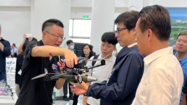 雷虎科技总经理苏圣杰（图左）向嘉义县长翁章梁（图右）及高雄市长陈其迈（图中）介绍自杀攻击无人机