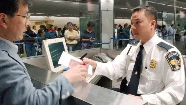 Un oficial de migración entrevista a un inmigrante.