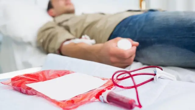 شاب يرقد على سرير لنقل الدم