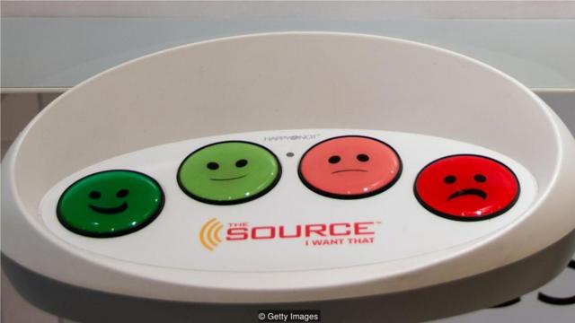 这种"笑脸"按钮如今普遍出现在商店和企业门口，比如希斯罗机场等地，来测量客户的心情(Credit: Getty Images)