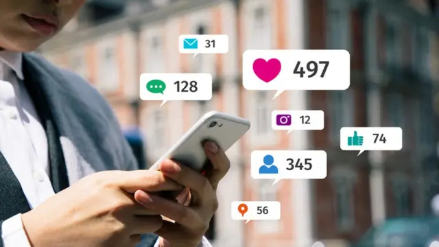 Una personas sostiene un teléfono con noticificaciones.