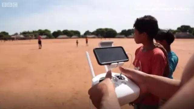 Jóvenes kuikuro manejando un drone.