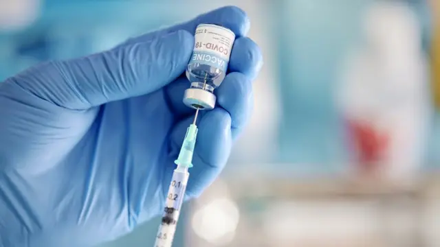 Un laborantin tenant un vaccin du Covid