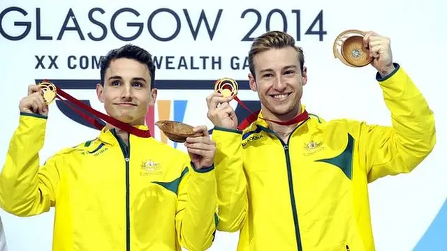 Australian divers Domonic Bedggood (left) and Matthew Mitcham (right) on the podium holding up their medals at the 2014 Glasgow Commonwealth Games