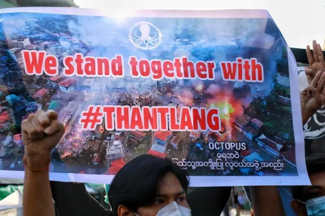 คนชูป้ายประท้วงในย่างกุ้ง