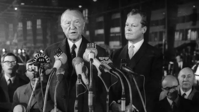 Konrad Adenauer discursa perante microfones da imprensa