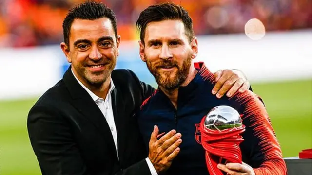 Xavi poses alongside Lionel Messi