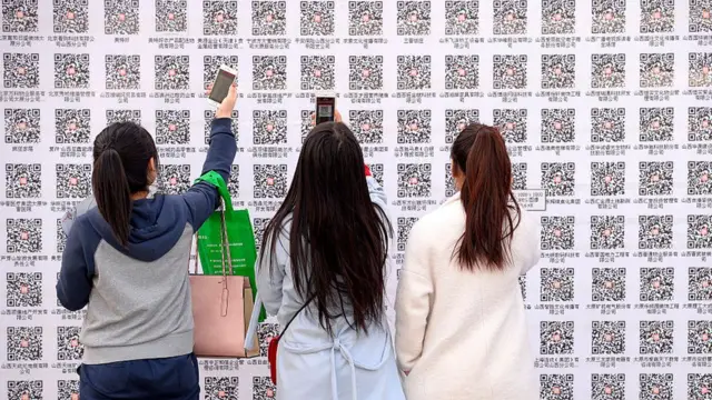 jóvenes leyendo un código QR a través de su teléfono móvil.