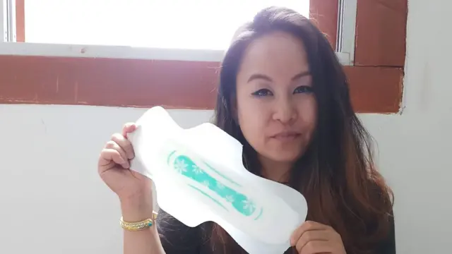 Arya Yogini holds her handmade sanitary pad.