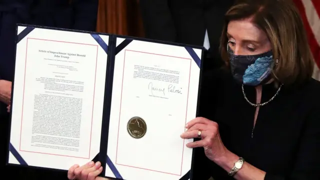 Nancy Pelosi mostrando la acusación contra Donald Trump