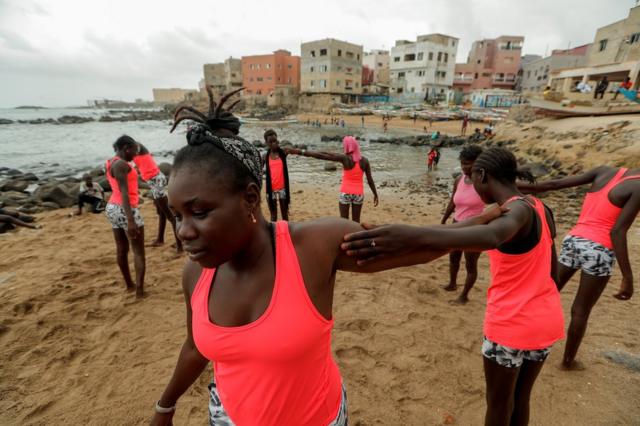 Khadjou Sambe enseigne aux filles et aux femmes les techniques de surf sur la plage