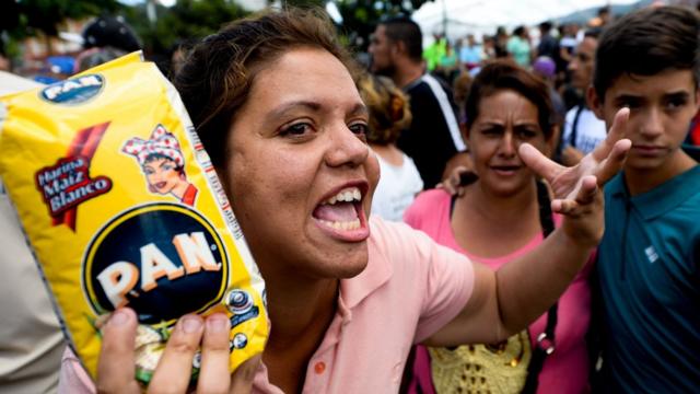 Una venezolana protesta con un kilo de harina de maíz precocida en la mano