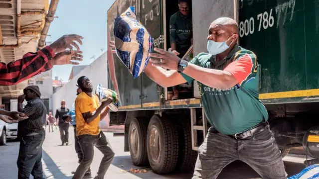 Volunteers prepare food parcels before a distribution leaded by the international NGO Gift to the Givers, in Johannesburg CBD, on October 14, 2020.