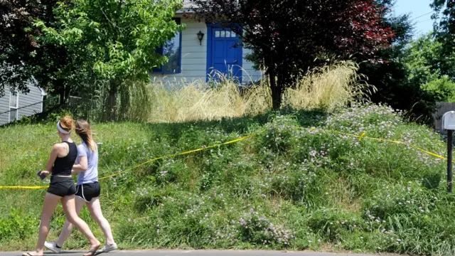 Dos personas caminan frente a la entrada de la casa de Kaplan.
