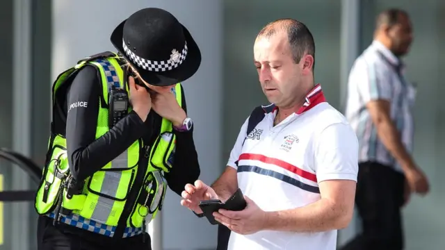 Сотрудница полиции разговаривает с прохожим