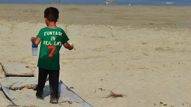 A local child on his way to play on the beach in Sai Wan...