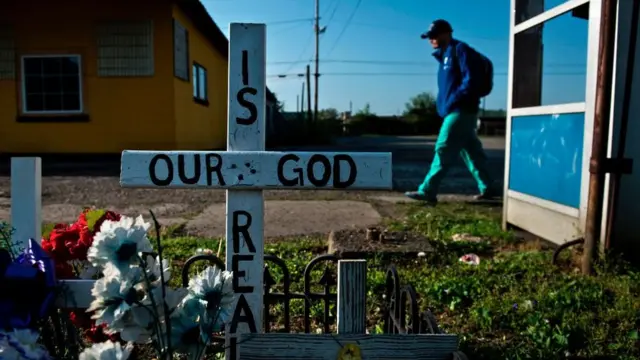 Una cruz enterrada en el pasto en Estados Unidos.