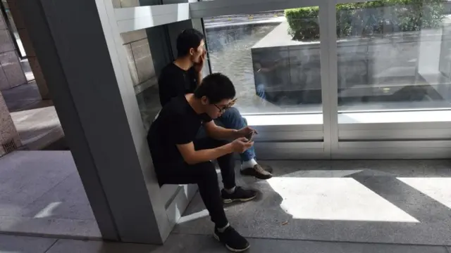 Dos trabajadores en un área para fumadores.