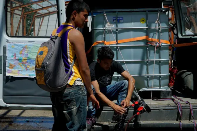 Furgoneta con agua y duchas portátiles en la fábrica abandonada donde se refugian los migrantes en Serbia.