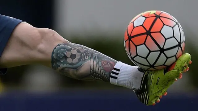 لاعب كرة قدم يظهر على قدمه صورة وشم