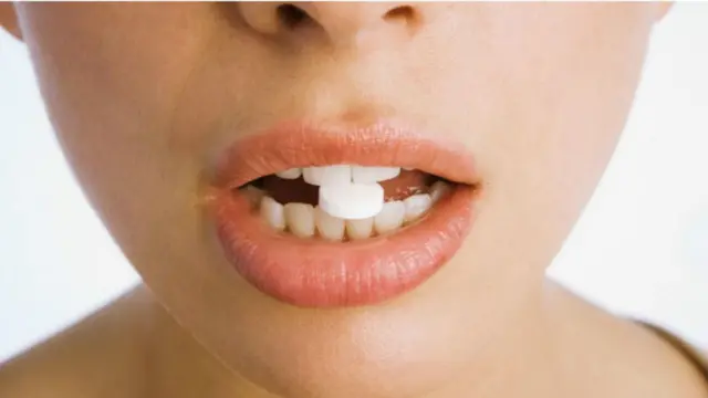 మాత్రను మింగుతున్న ఫోటో