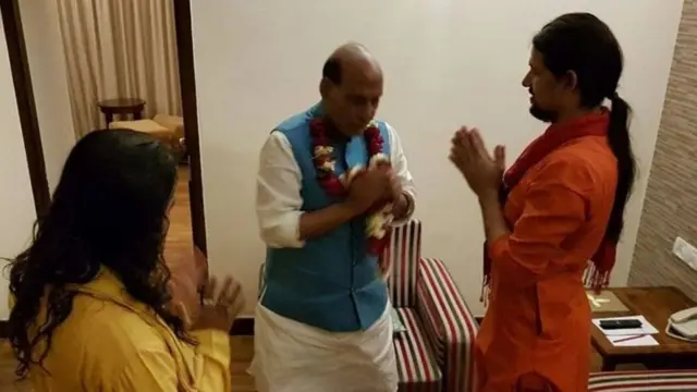 आनंद गिरी यांना हात जोडून प्रणाम करताना संरक्षण मंत्री राजनाथ सिंह