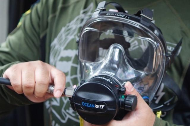 A Thai rescue worker prepares a full-face diving mask, 3 July 2018