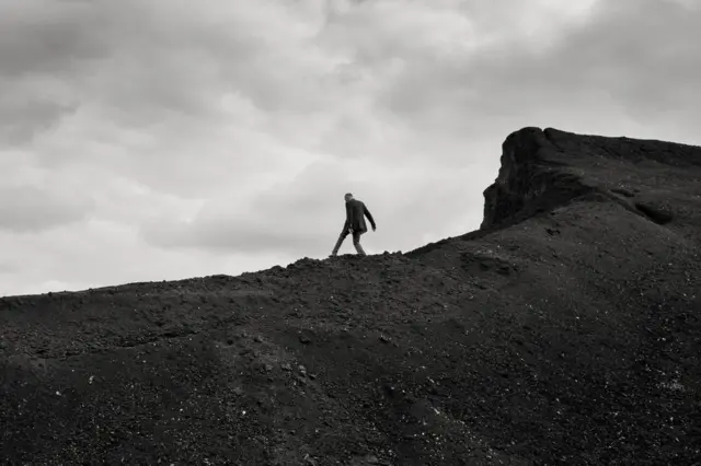 ایک آدمی پہاڑ کی چوٹی پر کھڑا ہے