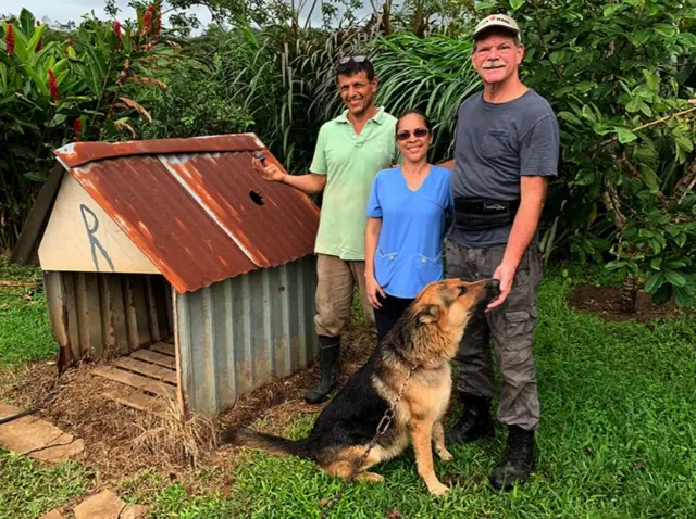 Roky posa com seus tutores ao lado de casinha de cachorro