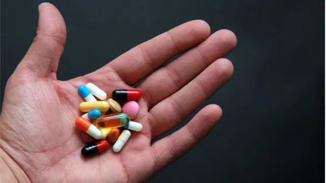 Рука с горстью таблеток