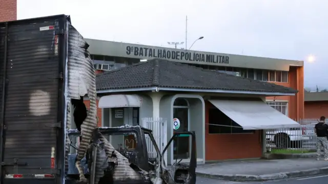 Caminhão destruído para bloqueia a saída do batalhão da Polícia Militar