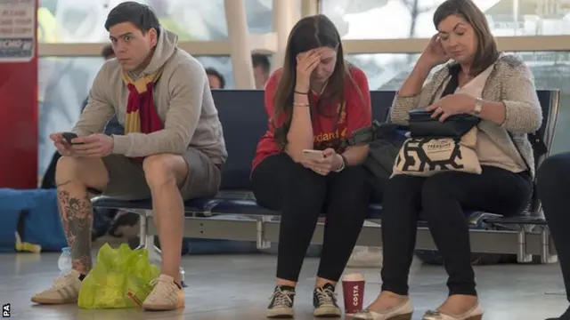 Liverpool fans look miserable in the airport